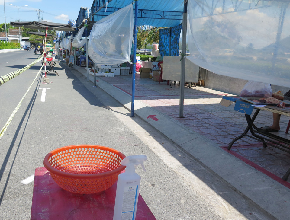 Mỗi gian hàng đều có khu vực để tiền trong rổ, chai khử khuẩn để người mua và người thực hiện phòng chống, dịch theo nguyên tắc 5K. (Ảnh: Phan Sáu/TTXVN)