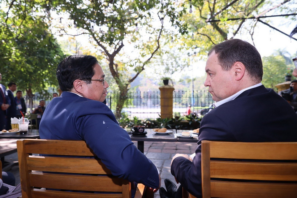 Thủ tướng Phạm Minh Chính và Thủ tướng Belarus Roman Golovchenko thưởng thức càphê trong không khí thân tình. (Ảnh: Dương Giang/TTXVN)