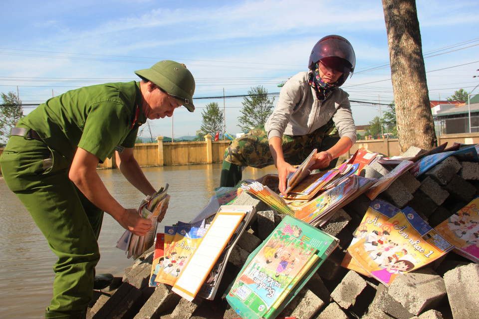 Lực lượng công an huyện Thạch Hà kịp thời có mặt để giúp giáo viên dọn dẹp sau lũ. (Ảnh: Hoàng Ngà/TTXVN)