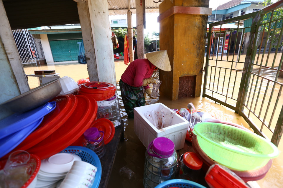 Người dân thôn Tân Phú, xã Cẩm Duệ dọn dẹp khi nước đang rút dần. (Ảnh: Minh Quyết/TTXVN)