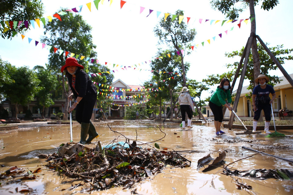 Cán bộ phòng giáo dục huyện Cẩm Xuyên cùng giáo viên trường tiểu học Cẩm Duệ vệ sinh trường, lớp học ngay khi nước đang rút dần. (Ảnh: Minh Quyết/TTXVN)