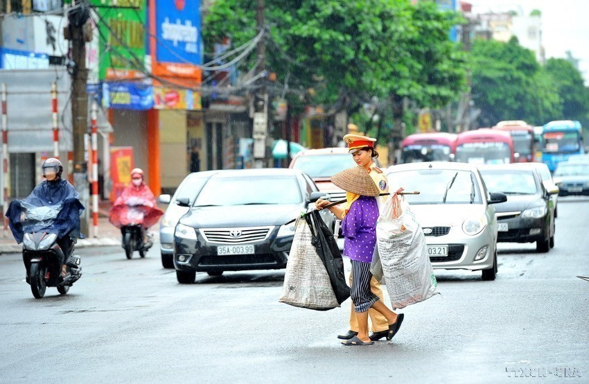 Nữ Cảnh sát Giao thông, Công an thành phố Ninh Bình giúp người khuyết tật sang đường. (Ảnh: Minh Đức/TTXVN)