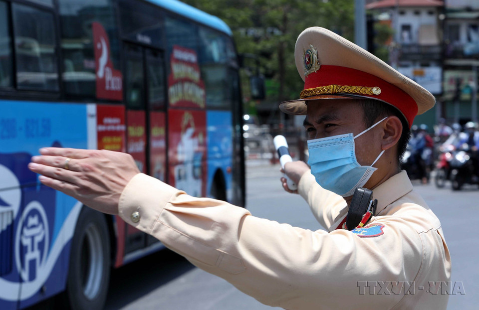 Chiến sỹ Cảnh sát Giao thông Hà Nội làm nhiệm vụ phân luồng, điều tiết giao thông tại ngã tư Đại Cồ Việt-Giải Phóng trong tình trạng nắng nóng lên tới 40 độ C. (Ảnh: Phạm Kiên/TTXVN)