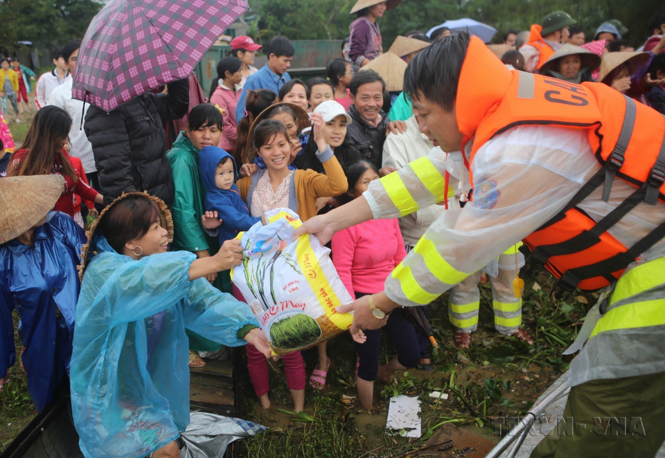 Lực lượng Cảnh sát Đường thủy, Công an tỉnh Thừa Thiên-Huế cứu trợ lương thực cho người dân xã Phú Mậu, huyện Phú Vang bị ảnh hưởng bởi lũ lụt (11/2017). (Ảnh: Hồ Cầu/TTXVN)