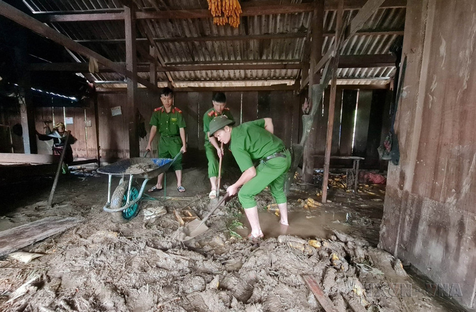 Công an huyện Than Uyên (Lai Châu) giúp dân dọn bùn đất tràn vào nhà do mưa lũ tại bản Hô Ta, xã Tà Mung. (Ảnh: TTXVN phát)