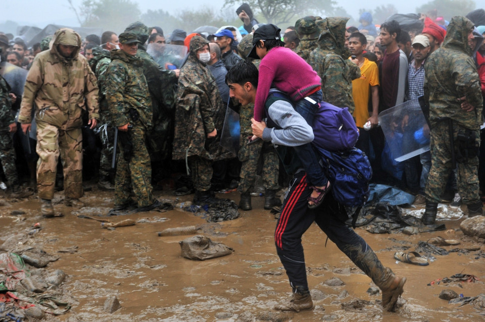 Một người nhập cư cho biết họ phải đợi 7 giờ dưới cơn mưa mà không có áo ấm hay đồ ăn. (Ảnh: AFP)