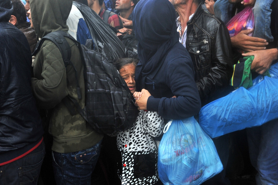 Những người nhập cư không có áo mưa để chống chọi với cơn mưa tầm tã. (Ảnh: AFP)