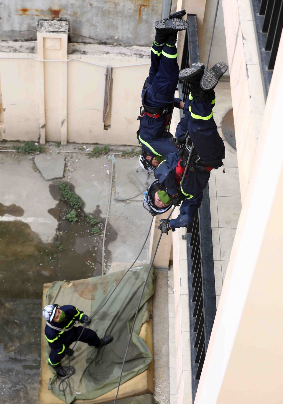 Thiếu tá Nguyễn Thị Ngọc Lan luyện tập bài xuống trong tư thế cắm đầu từ toà nhà cao tầng. (Ảnh: Phạm Kiên/TTXVN)