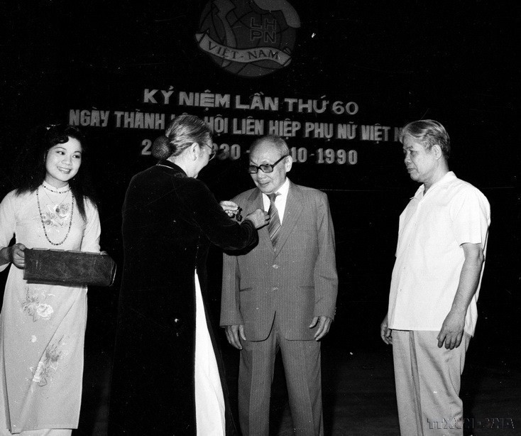 Đồng chí Nguyễn Thị Định, Phó Chủ tịch Hội đồng Nhà nước, Chủ tịch Hội Liên hiệp Phụ nữ Việt Nam gắn huân chương "Vì sự nghiệp giải phóng phụ nữ" cho Chủ tịch Hội đồng Nhà nước Võ Chí Công tại lễ míttinh kỷ niệm 60 năm Ngày thành lập Hội (18/10/1990). (Ảnh: TTXVN)