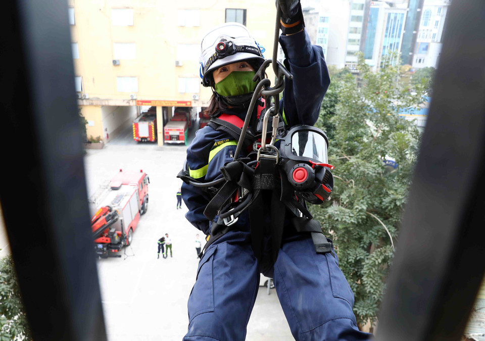 Thiếu tá Nguyễn Thị Ngọc Lan thoăn thoắt đu mình từ trên cao xuống. (Ảnh: Phạm Kiên/TTXVN)