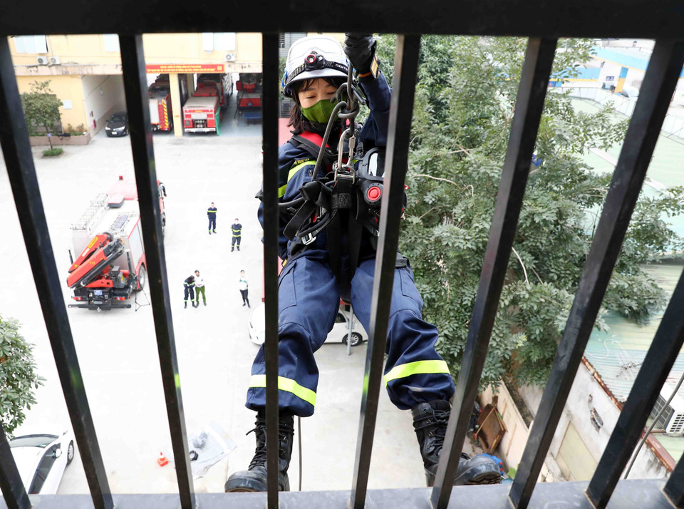 Thiếu tá Nguyễn Thị Ngọc Lan trong bài luyện đu dây từ trên cao xuống. (Ảnh: Phạm Kiên/TTXVN)