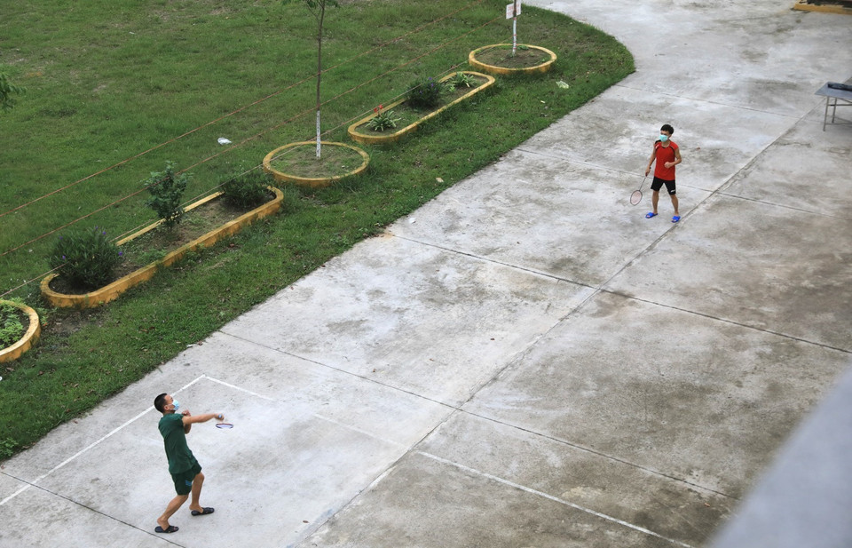 Người dân đeo khẩu trang chơi các môn thể thao như cầu lông, đá cầu giữ khoảng cách ăn toàn ít nhất hơn 2m tránh lây nhiễm chéo. (Ảnh: Thành Đạt/TTXVN)