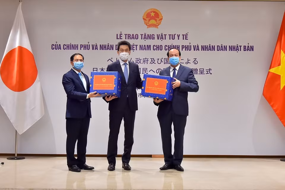 Bộ trưởng, Chủ nhiệm Văn phòng Chính phủ Mai Tiến Dũng (phải) và Thứ trưởng Thường trực Bộ Ngoại giao Bùi Thanh Sơn(trái) trao vật tư y tế cho Phó Đại sứ Nhật Bản tại Việt Nam Shinichi Asazuma. (Ảnh: Dương Giang/TTXVN)