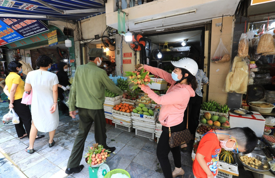 Tại khu vực chợ Hàng Bè, lực lượng chức năng phường Hàng Bạc tuyên truyền, nhắc nhở người dân không họp chợ, tránh tụ tập đông người để phòng, chống dịch. (Ảnh: Thành Đạt/TTXVN)