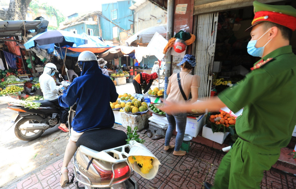 Lực lượng chức năng quận Hai Bà Trưng nhắc nhở, yêu cầu người dân không họp chợ gây lấn chiếm vỉa hè lòng đường để phòng chống dịch. (Ảnh: Thành Đạt/TTXVN)
