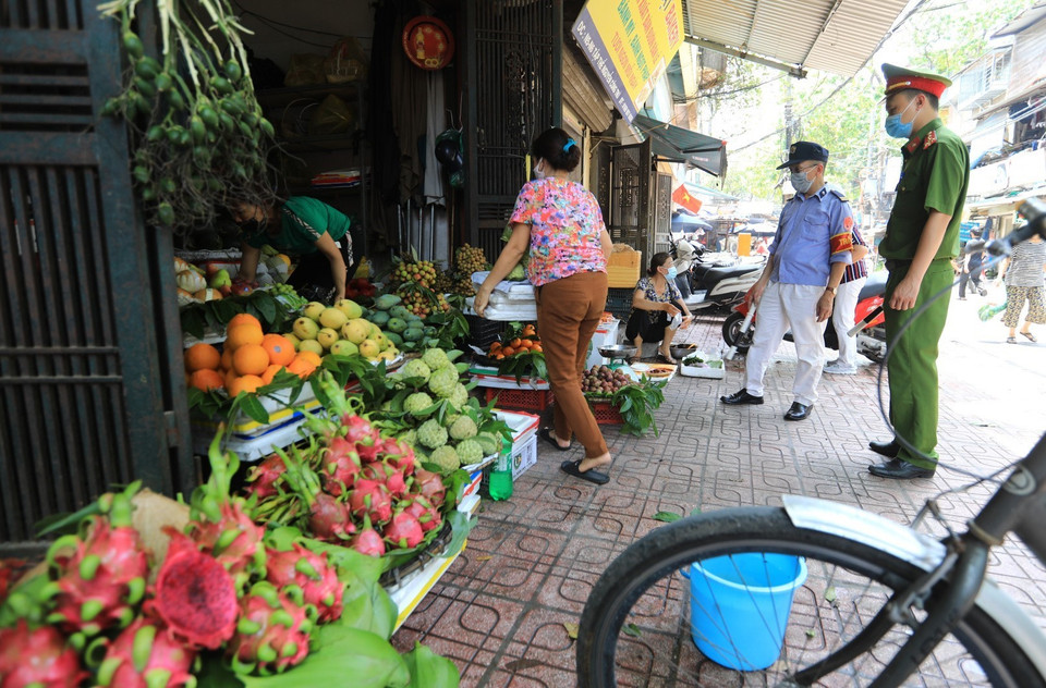 Lực lượng chức năng giải tỏa các chợ cóc, chợ tạm lấn chiếm vỉa hè, lòng đường nguy cơ lây lan dịch bệnh COVID-19 để chống dịch tại khu vực chợ Nguyễn Công Trứ. (Ảnh: Thành Đạt/TTXVN)