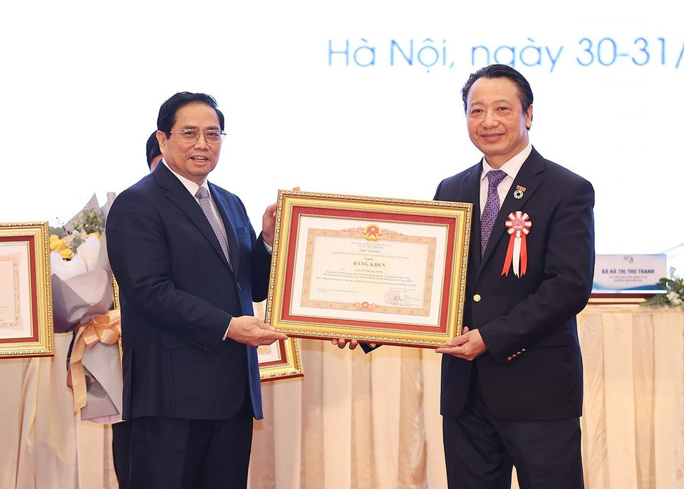 Thủ tướng Phạm Minh trao Bằng khen cho ông Nguyễn Quang Vinh, Tổng Thư ký VCCI. (Ảnh: Dương Giang/TTXVN)