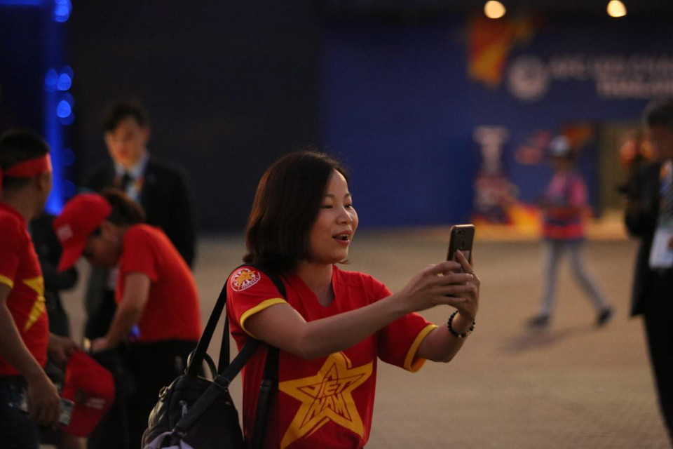 Các nữ cổ động viên tranh thủ chụp hình trước khi vào sân. (Ảnh: Nguyên An/Vietnam+)