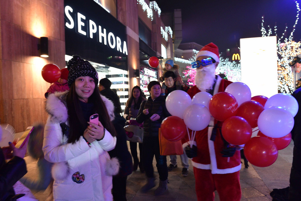 Ông già Noel phát bóng bay cho các bạn trẻ. (Ảnh: Tường Thu/Vietnam+) 