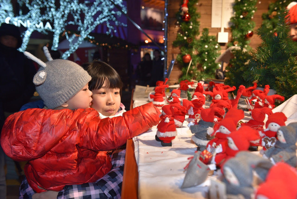 Hai chị em thích thú với những con búp bê len kiểu Pháp. (Ảnh: Tường Thu/Vietnam+)