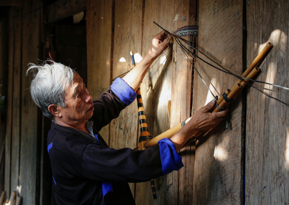 Nghệ nhân Thào Cáng Súa cẩn thận treo khèn lên sau khi hoàn thiện. (Ảnh: Tuấn Anh/TTXVN)