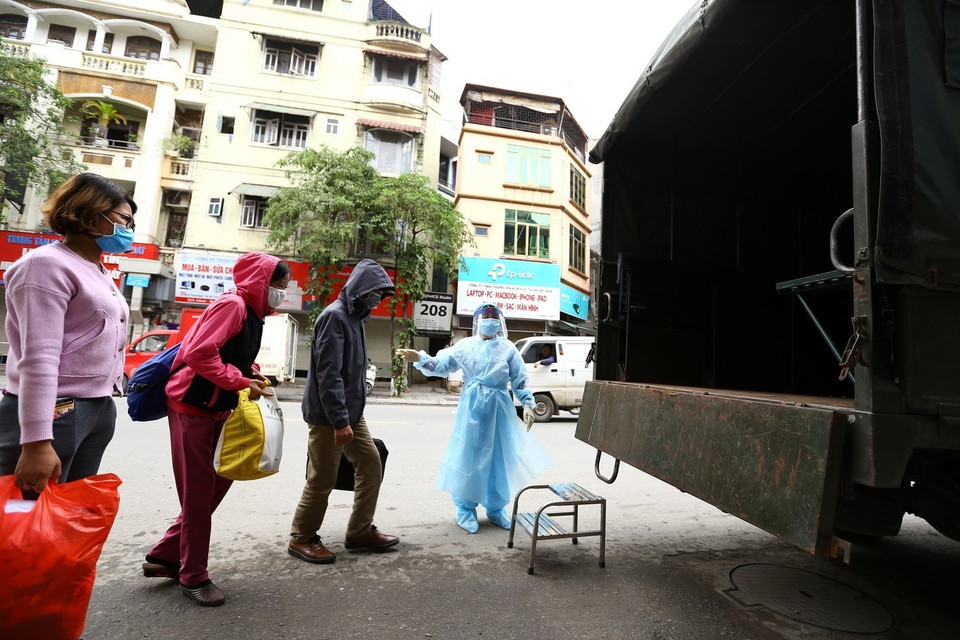 Nhân viên y tế bệnh viện Bạch Mai hướng dẫn các bệnh nhân ra xe, di chuyển vào bệnh viện. (Ảnh: Minh Quyết/TTXVN)