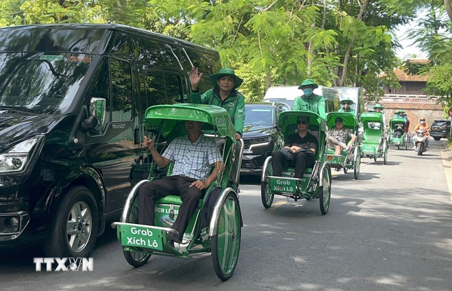 Người dân trải nghiệm mô hình dịch vụ Grab Xích lô tại Huế. (Ảnh: Văn Dũng/TTXVN) ttxvn-grap-hue.jpg