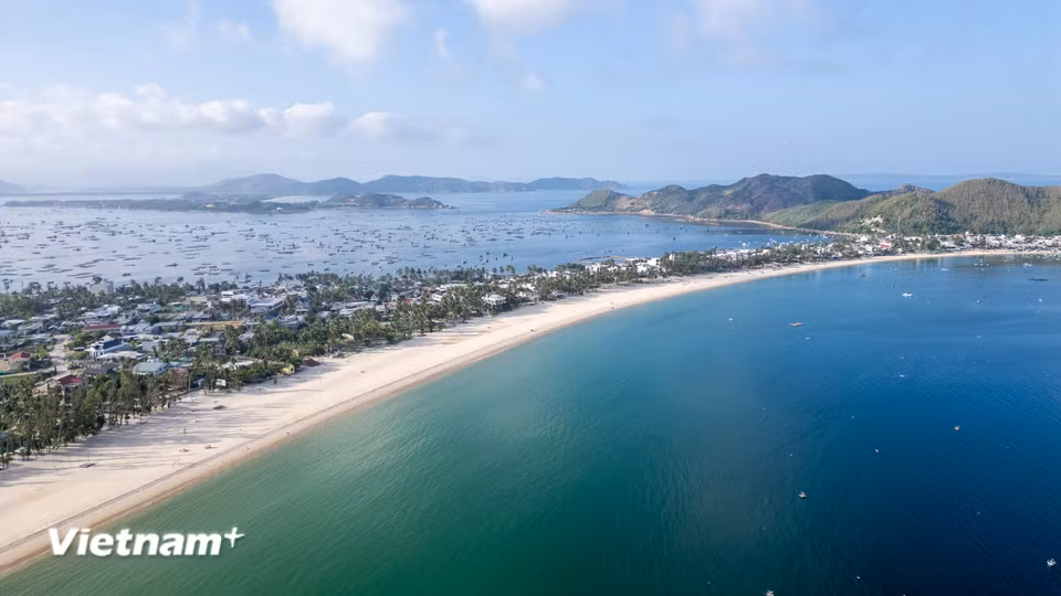 Bãi biển Vịnh Hòa (thuộc phường Sông Cầu, tỉnh Đắk Lắk) nhìn từ trên cao mang vẻ đẹp hoang sơ, thơ mộng với đường bờ biển uốn cong mềm mại, hòa quyện giữa làn nước biển trong xanh và bãi cát trắng mịn màng. (Ảnh: Thanh Phong/Vietnam+)