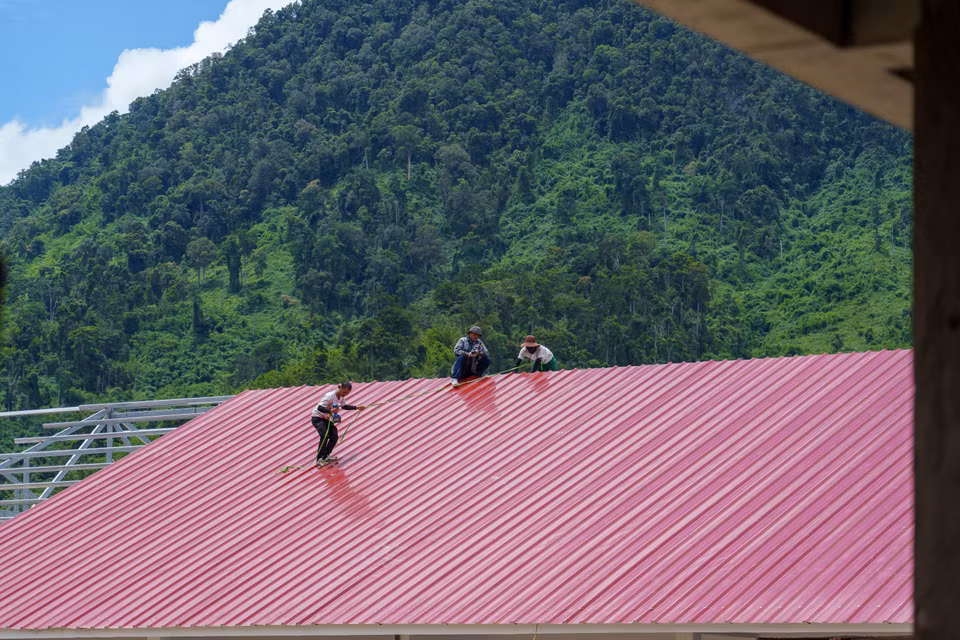 Công nhân kiểm tra kỹ lưỡng các khớp nối tôn, đảm bảo chất lượng cho công trình. (Ảnh: Thanh Phong/Vietnam+)