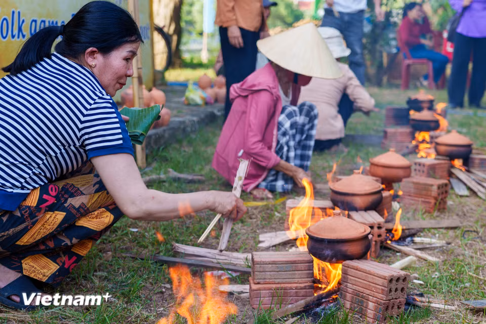 Người tham gia thi tài khéo léo điều chỉnh ngọn lửa củi để đảm bảo nồi cơm đất chín đều và giữ được hương vị. (Ảnh: Thanh Phong/Vietnam+)