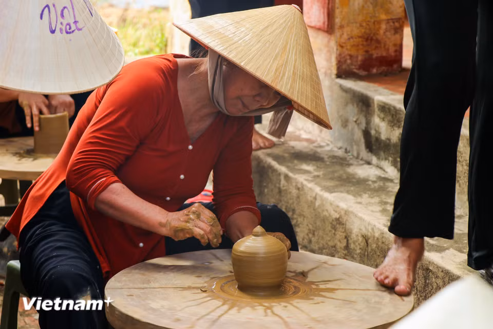 Nghệ nhân nhịp nhàng tạo hình gốm trên bàn xoay truyền thống được điều khiển hoàn toàn bằng sức đẩy của đôi bàn chân. (Ảnh: Thanh Phong/Vietnam+)