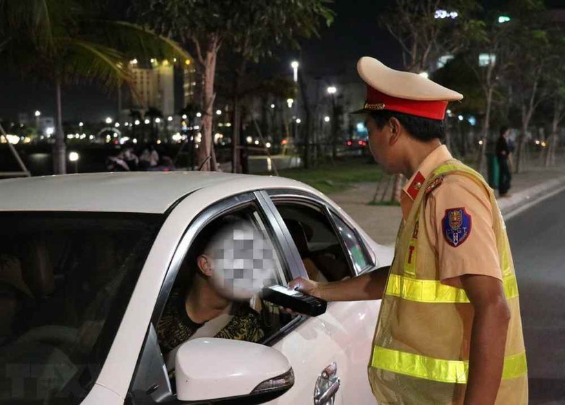 Cảnh sát Giao thông kiểm tra nồng độ cồn đối với người điều khiển xe ôtô. (Ảnh: Xuân Triệu/TTXVN)