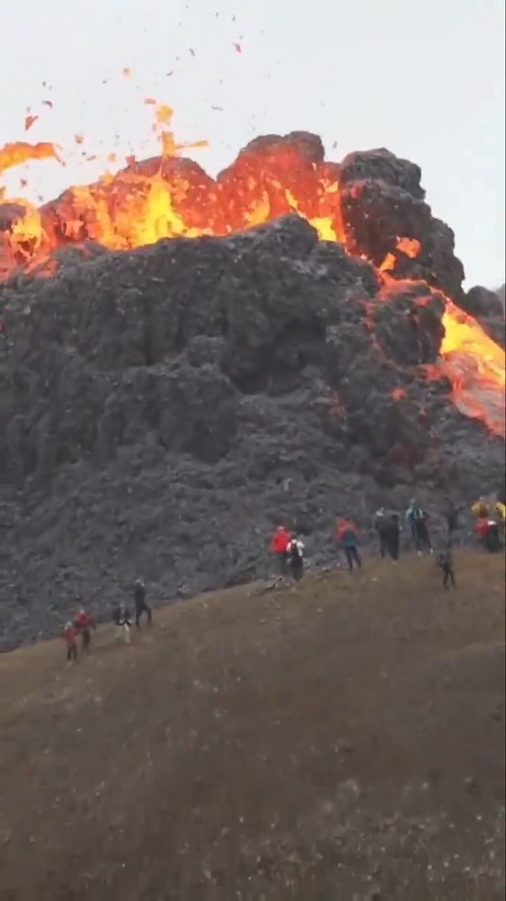 Du khách đứng sát miệng núi lửa để xem nham thạch phun trào ở Iceland