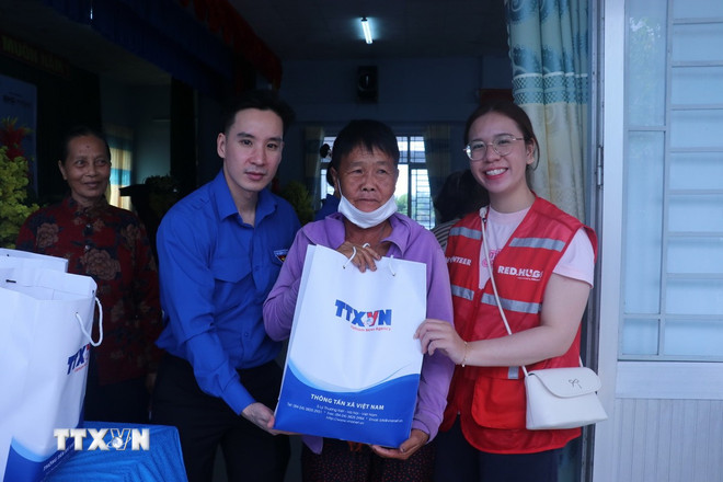 Anh Huỳnh Long Hồ - Bí thư Đoàn thanh niên Trung tâm thông tin TTXVN khu vực phía Nam tặng quà cho người dân có hoàn cảnh khó khăn ở xã Tân Tây, tỉnh Tây Ninh. (Ảnh: Bùi Giang/TTXVN) ttxvn-0507-thanh-nien-3.jpg