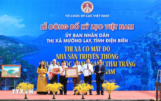Trao chứng nhận xác lập kỷ lục “Thị xã có mật độ nhà sàn truyền thống của dân tộc Thái ngành Thái trắng nhiều nhất Việt Nam” cho lãnh đạo thị xã Mường Lay, tỉnh Điện Biên. (Ảnh: Phan Quân/TTXVN) ttxvn-0805-nha-san-thai-trang-muong-lay-dien-bien.jpg