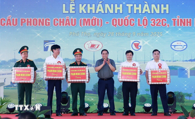 Prime Minister Pham Minh Chinh presents gifts to contractors and construction units of the new Phong Chau bridge project. (Photo: Duong Giang/VNA) ttxvn-2809-thu-tuong-cau-phong-chau-11.jpg
