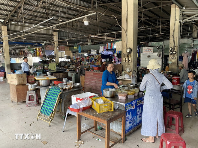Gian hàng ăn uống bên trong chợ Hà Thân chỉ có vài quầy hàng hoạt động cầm chừng, phục vụ các tiểu thương tại chợ. (Ảnh Xuân Quý/TTXVN) ttxvn-1107-cho-ha-than-da-nang-2.jpg