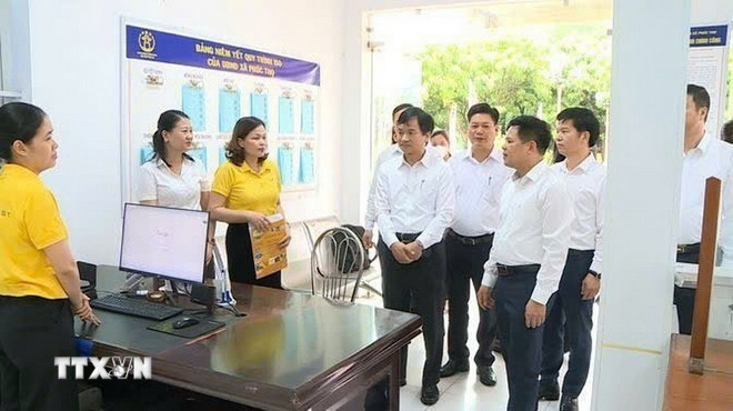 Lãnh đạo xã Phúc Thọ kiểm tra điểm phục vụ hành chính công sau hai tháng thực hiện chính quyền hai cấp. (Ảnh: Quốc Lũy/TTXVN) ttxvn-0510-ha-noi-chinh-quyen-2-cap-6jpg.jpg