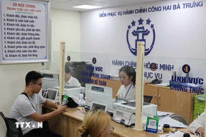 Người dân được cán bộ, công chức hỗ trợ giải quyết hồ sơ tại Điểm phục vụ Hành chính công phường Hai Bà Trưng (Hà Nội). (Ảnh: Vũ Quang/TTXVN) ttxvn-0510-ha-noi-chinh-quyen-2-cap-5-2886.jpg