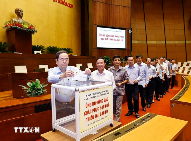 ប្រធានរដ្ឋសភាវៀតណាម លោក Tran Thanh Man រួមជាមួយថ្នាក់ដឹកនាំរដ្ឋសភា មន្ត្រី និងបុគ្គលិកនៃស្ថាប័នរដ្ឋសភា បានអញ្ជើញចូលរួមពិធីជួយឧបត្ថម្ភប្រជាពលរដ្ឋជំនះពុះពារផលវិបាកនៃគ្រោះធម្មជាតិ និងទឹកជំនន់។ (រូបថត៖ Doan Tan/VNA) ttxvn-0210-chu-tich-quoc-hoi-ung-ho-dong-bao-bao-lu.jpg