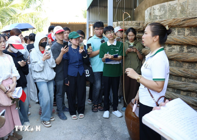 Đại diện Công ty TNHH thực phẩm và gia vị JiJi Ninh Thuận (xã Tri Hải, huyện Ninh Hải) giới thiệu quy trình sản xuất nước mắm cá cơm truyền thống tới du khách. (Ảnh: Nguyễn Thành/TTXVN) ttxvn-2606-du-lich-ninh-thuan-3.jpg