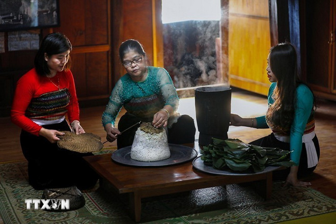 Setelah matang, nasi ketan dikipas-kipas hingga dingin, lalu dibungkus menjadi kotak-kotak kecil menggunakan daun dong. Metode pembungkusan ini membantu nasi ketan mempertahankan aromanya dan juga mudah dipajang di nampan persembahan. (Foto: Trong Dat/VNA) ttxvn-0912-le-mung-com-moi-dan-toc-thai-8.jpg