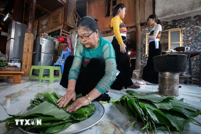 Ibu Ha Thi Ung di Desa Pom Coong (Mai Chau, Phu Tho) menyiapkan daun dong untuk membungkus nasi ketan dalam upacara tersebut. (Foto: Trong Dat/VNA) ttxvn-0912-le-mung-com-moi-dan-toc-thai-10.jpg