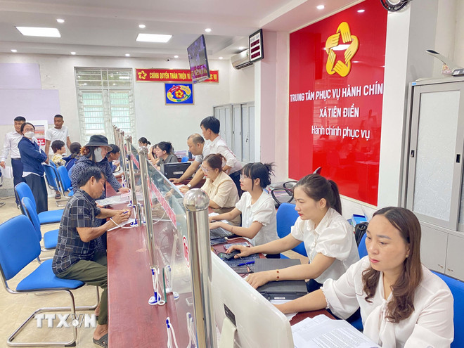 Masyarakat datang untuk mengurus administrasi di Pusat Layanan Administrasi Publik Komune Tien Dien (Ha Tinh). (Foto: Huu Quyet/VNA) ttxvn-3009-ha-tinh-chinh-quyen-dia-phuong-2-cap.jpg