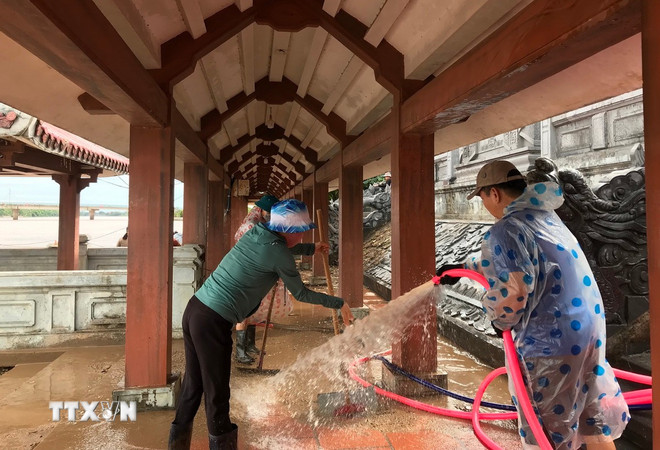 Dọn dẹp vệ sinh tại Bến thả hoa bờ Nam sông Thạch Hãn, thị xã Quảng Trị. (Ảnh: Thanh Thủy/TTXVN) ttxvn-1406-quang-tri-mua-lu-2.jpg