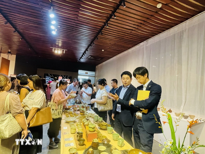 代表団と来場者が展示会でプーラン陶器製品(バクニン省)を見学(写真:トゥエット・マイ/VNA) ttxvn-1909-van-hoa-viet-nam-nhat-ban-2.jpg