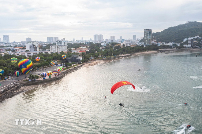 Atividades esportivas aquáticas e apresentações de balões de ar quente na área de Front Beach (bairro de Vung Tau) atraem um grande número de pessoas e turistas para conferir e vivenciar a experiência. (Foto: VNA) ttxvn-1510-bien-vung-tau.jpg