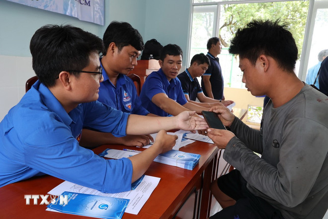El personal de Sawaco instruye a los usuarios sobre cómo utilizar la aplicación de pago de facturas de agua en línea desde sus teléfonos. (Foto: Anh Tuan/VNA) ttxvn-2910-sawaco-2.jpg