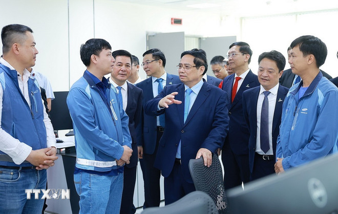 Premiärminister Pham Minh Chinh med ingenjörer och experter som driver LNG-kraftverken Nhon Trach 3 och 4. (Foto: Duong Giang/VNA) ttxvn-1412-thu-tuong-nha-may-dien-khi-nhon-trach-9.jpg