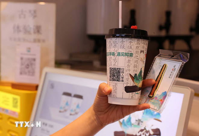 Visitors buy tea, scan the QR code and enjoy tea with the sound of a guqin, and do not forget to take a photo to “check-in” with a cup of milk tea and a souvenir shaped like a guqin. (Photo: Van Diep/VNA) ttxvn-2205-vu-han-4.jpg